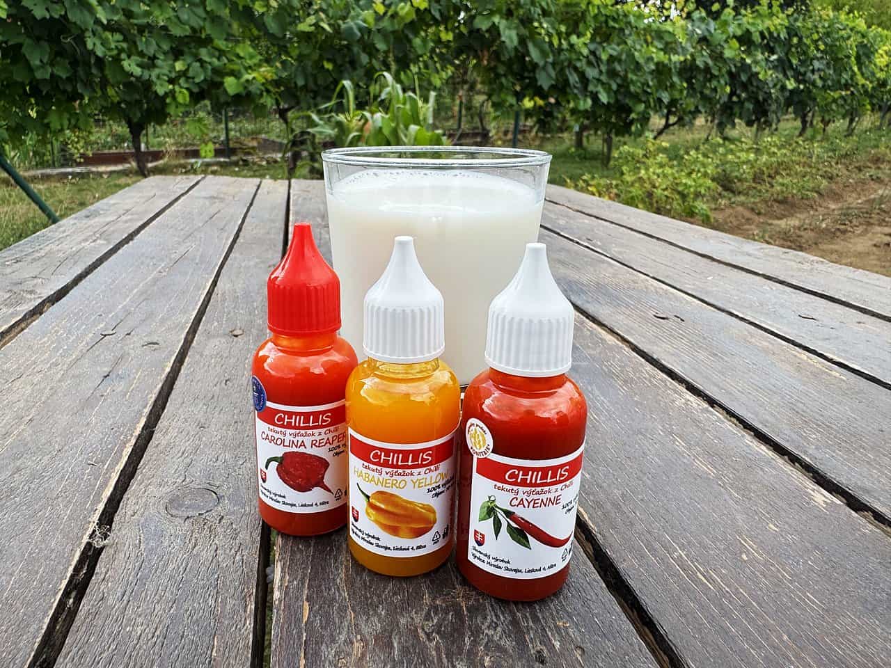 Pohár mlieka a fľaštičky tekutého chilli Chillis