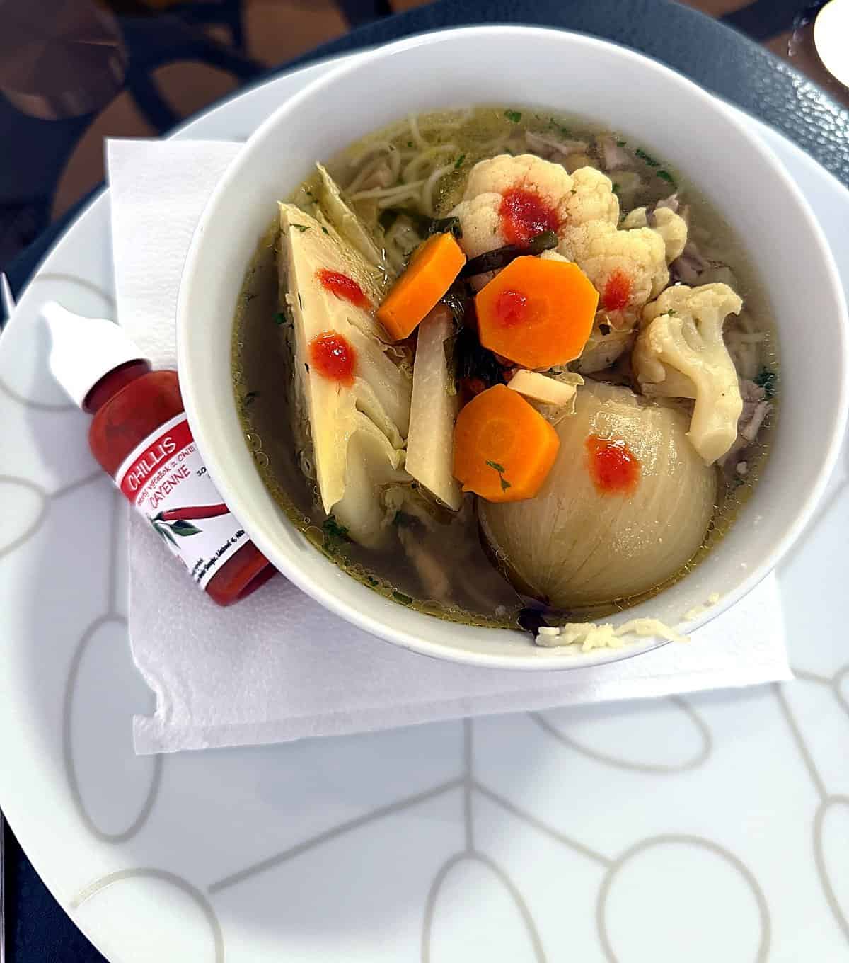 Hotová polievka dochutená tekutým chilli Cayenne, vedľa fľaštička Chillis 30 ml